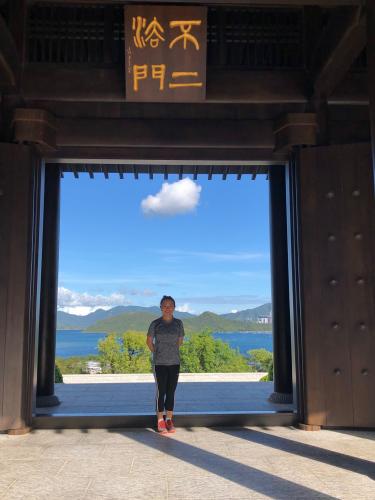 a picture of Hong Hu standing in front of a lake
