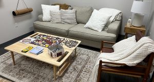 a photo of the wellness room with a sofa and a table with a puzzle on it