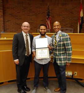 litton, joshi and henson standing in the mizzou law courtroom with joshi holding the certificate