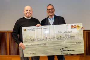 a photo of parker owens and the director of the competition holding a giant check for $15,000