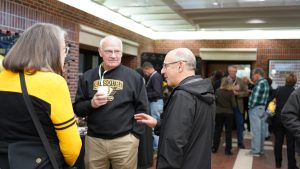 a photo of dean litton speaking with alumni at the tailgate