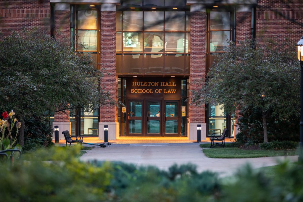 a photo of the front door of hulston hall with a School of Law sign above the door