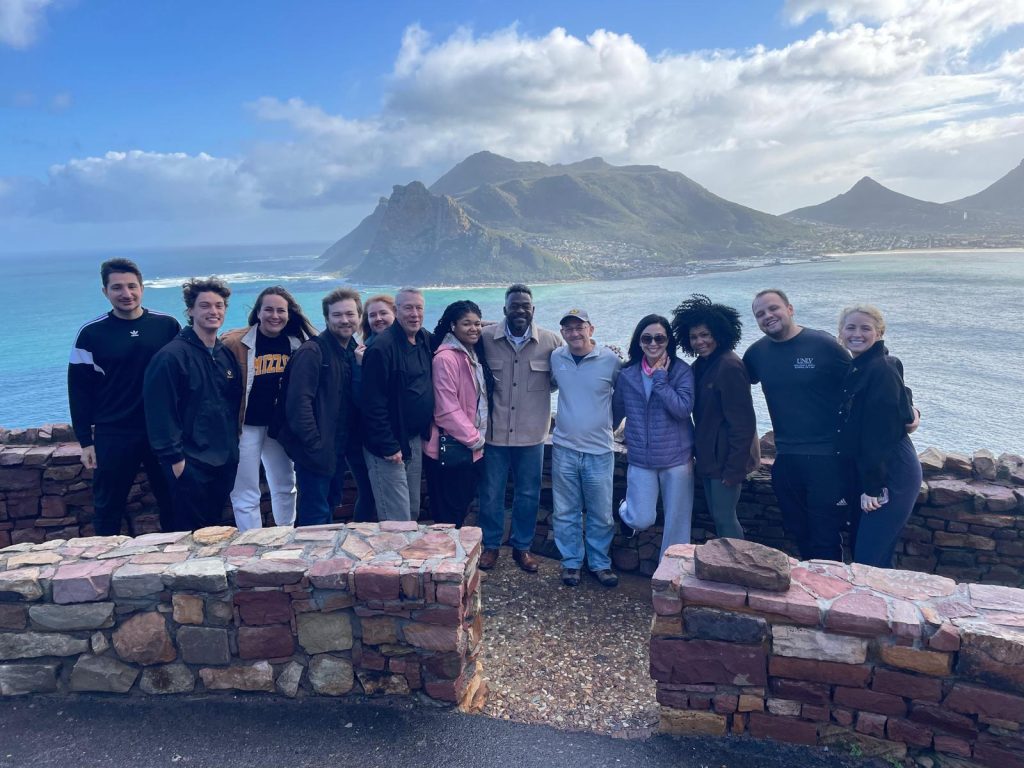 students and dean litton in front of the ocean