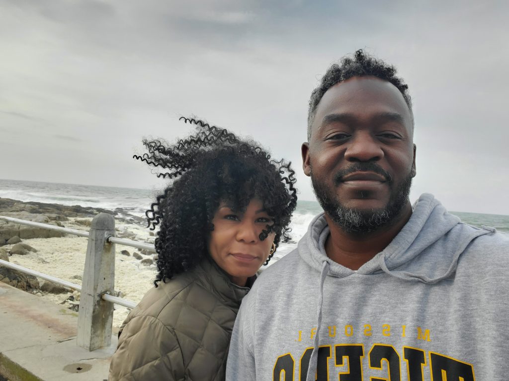 a photo of two students in front of the ocean
