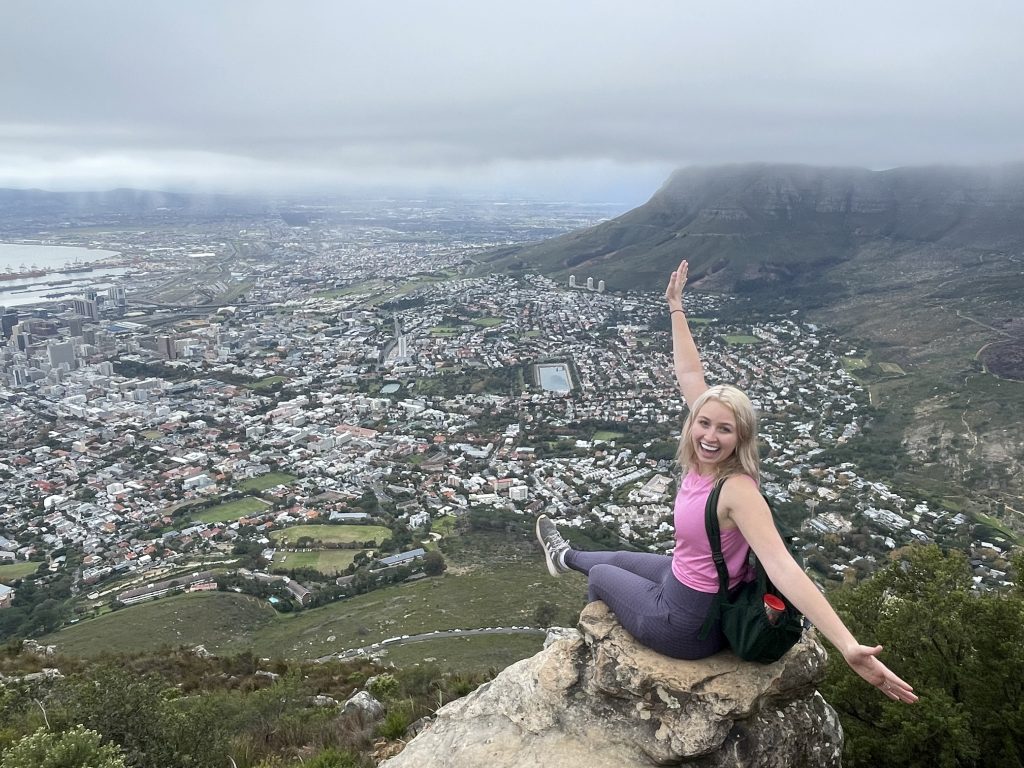 a photo of a woman on top of a cliff overlooking cape town