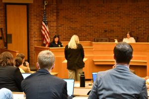 A CPC student interviews a police officer in a mock hearing